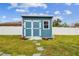 Blue storage shed in the backyard with white fence at 3400 Lake Padgett Dr, Land O Lakes, FL 34639