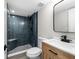 Modern bathroom with blue tile shower and wood vanity at 400 64Th Ave # 502, St Pete Beach, FL 33706