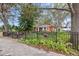 Front view of a red house with a black fence and lush landscaping at 4334 3Rd N Ave, St Petersburg, FL 33713