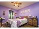 Lavender bedroom with floral bedding and built-in wooden shelving at 4533 Ashburn Square Dr # 4533, Tampa, FL 33610