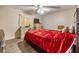 Bedroom with red bedspread, dresser, and ceiling fan at 5322 Comanche St, Zephyrhills, FL 33542