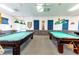 Game room with two pool tables and blue window shades at 5322 Comanche St, Zephyrhills, FL 33542