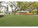 Landscaped yard showcasing a white house with black window frames and a wooden fence at 5816 Woodrow Wilson Ne Blvd, St Petersburg, FL 33703