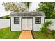 White shed with double doors and two windows at 5816 Woodrow Wilson Ne Blvd, St Petersburg, FL 33703