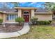 House with red double doors and manicured landscaping at 599 Centerwood Dr, Tarpon Springs, FL 34688