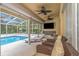 Inviting poolside patio with wicker furniture and TV at 599 Centerwood Dr, Tarpon Springs, FL 34688