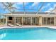 Large screened pool and patio with lounge chairs and house view at 599 Centerwood Dr, Tarpon Springs, FL 34688