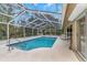 Screened pool and patio with lounge chairs and partial house view at 599 Centerwood Dr, Tarpon Springs, FL 34688