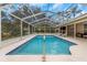 Refreshing pool with screened enclosure and patio furniture at 599 Centerwood Dr, Tarpon Springs, FL 34688