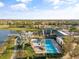 Aerial view of a large community pool, adjacent lake, with lush landscaping and a pier at 6307 Brevada Ln, Apollo Beach, FL 33572