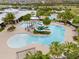 Overhead view of resort-style community pool with water slide, sun loungers, and lush palm trees at 6307 Brevada Ln, Apollo Beach, FL 33572