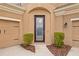 Elegant front entryway showcasing a decorative glass door and manicured bushes at 6307 Brevada Ln, Apollo Beach, FL 33572