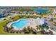 Aerial view of community pool with ample seating, palm trees, and adjacent recreation areas by the lake at 6307 Brevada Ln, Apollo Beach, FL 33572