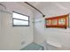 Simple bathroom with light blue tile, shower, and a window at 6327 5Th Street E Cir, Bradenton, FL 34203