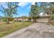 House exterior with a driveway, landscaping, and mature trees at 6327 5Th Street E Cir, Bradenton, FL 34203