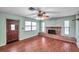 Living room featuring hardwood floors, a brick fireplace, and ceiling fan at 6327 5Th Street E Cir, Bradenton, FL 34203