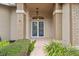 Front entrance with double doors and brick columns at 7473 Willow Brook Dr, Spring Hill, FL 34606