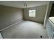 Upstairs bedroom with window and neutral colored walls at 7533 Merchantville Cir, Zephyrhills, FL 33540