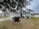 Gray two-story house with attached garage and landscaping at 7533 Merchantville Cir, Zephyrhills, FL 33540