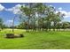 Grassy field with a green, several trees, bushes and a bench at 7724 St Andrews Blvd, Weeki Wachee, FL 34613