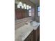 Bathroom with vanity, light pink tile, and mirror at 7930 Valmy Ln, Port Richey, FL 34668