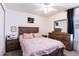 Well-lit bedroom with wooden furniture and pink bedding at 7943 Merchantville Cir, Zephyrhills, FL 33540