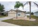 Tan house with two palm trees and a two-car garage at 7943 Merchantville Cir, Zephyrhills, FL 33540