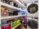 Laundry room with washer, dryer, and ample shelving at 7943 Merchantville Cir, Zephyrhills, FL 33540