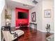 Living room with hardwood floors, a red accent wall, and comfortable seating at 8811 Casablanca Way # 106, Tampa, FL 33626