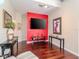 Living room with hardwood floors, a red accent wall, and comfortable seating at 8811 Casablanca Way # 106, Tampa, FL 33626