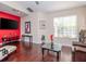 Living room with hardwood floors, a red accent wall, and comfortable seating at 8811 Casablanca Way # 106, Tampa, FL 33626