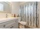 Bathroom with gray vanity, shower, and patterned shower curtain at 9070 Bryan Dairy Rd, Seminole, FL 33777