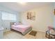 Bedroom with pink bedding, wall art, and ceiling light at 9070 Bryan Dairy Rd, Seminole, FL 33777