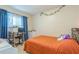 Bedroom with orange bedding, desk and chair, and window with curtains at 9070 Bryan Dairy Rd, Seminole, FL 33777