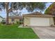 House exterior featuring a one-story house with a two-car garage and well-maintained lawn at 9070 Bryan Dairy Rd, Seminole, FL 33777