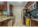 Kitchen featuring dark brown cabinets, granite countertops, and stainless steel appliances at 9070 Bryan Dairy Rd, Seminole, FL 33777