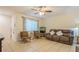 Living room with two brown accent chairs, a couch, and tile flooring at 9070 Bryan Dairy Rd, Seminole, FL 33777