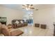 Living room showcasing a brown couch, two accent chairs, and tile flooring at 9070 Bryan Dairy Rd, Seminole, FL 33777