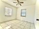 Bright, empty bedroom with tile flooring, ceiling fan, and natural light from two windows at 963 27Th S Ave, St Petersburg, FL 33705