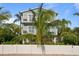 Two-story house with light blue siding, balconies, and tropical landscaping at 2203 Avenue B, Bradenton Beach, FL 34217