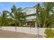 Two-story house with light blue siding, balconies, and a fenced backyard at 2203 Avenue B, Bradenton Beach, FL 34217