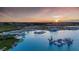 Aerial view of Crystal Lagoon at sunset with surrounding landscape at 10024 Trumpet Honeysuckle Way, San Antonio, FL 33576