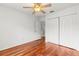 Hardwood floor bedroom with ceiling fan and double door closet at 10525 Lucaya Dr, Tampa, FL 33647