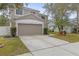 Two-story house with beige exterior, two-car garage, and manicured lawn at 10525 Lucaya Dr, Tampa, FL 33647