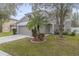 Two-story house with beige exterior, two-car garage, and palm trees at 10525 Lucaya Dr, Tampa, FL 33647