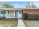 Brick and light blue home with rocking chairs on porch at 11012 N Oregon Ave, Tampa, FL 33612