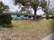 House exterior showcasing a light blue facade and mature landscaping at 11012 N Oregon Ave, Tampa, FL 33612