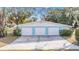 Three-car garage with light blue exterior and white doors at 11012 N Oregon Ave, Tampa, FL 33612