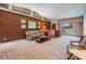 Mid-century living room featuring brick wall, floral sofa, and ample natural light at 11012 N Oregon Ave, Tampa, FL 33612