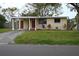 Front view of a ranch house with a carport and a well-maintained lawn at 11798 104Th St, Largo, FL 33773